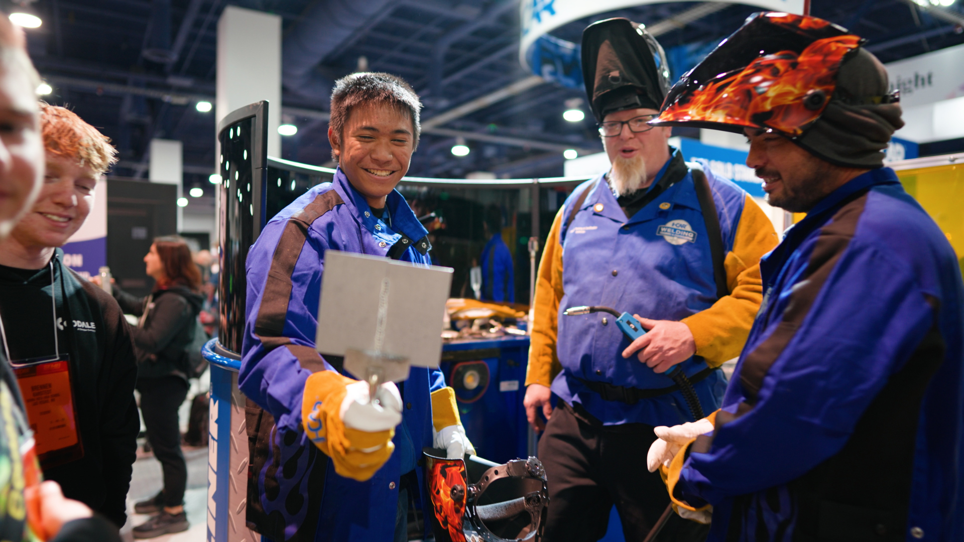 Team members in blue and yellow jackets collaborating at technical conference