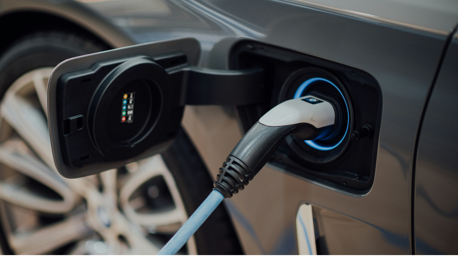 Electric vehicle charging cable plugged into car charging port