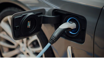 Electric vehicle charging cable plugged into car charging port
