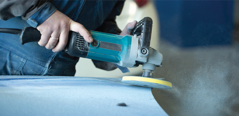 Teal angle grinder polishing surface with yellow buffing pad