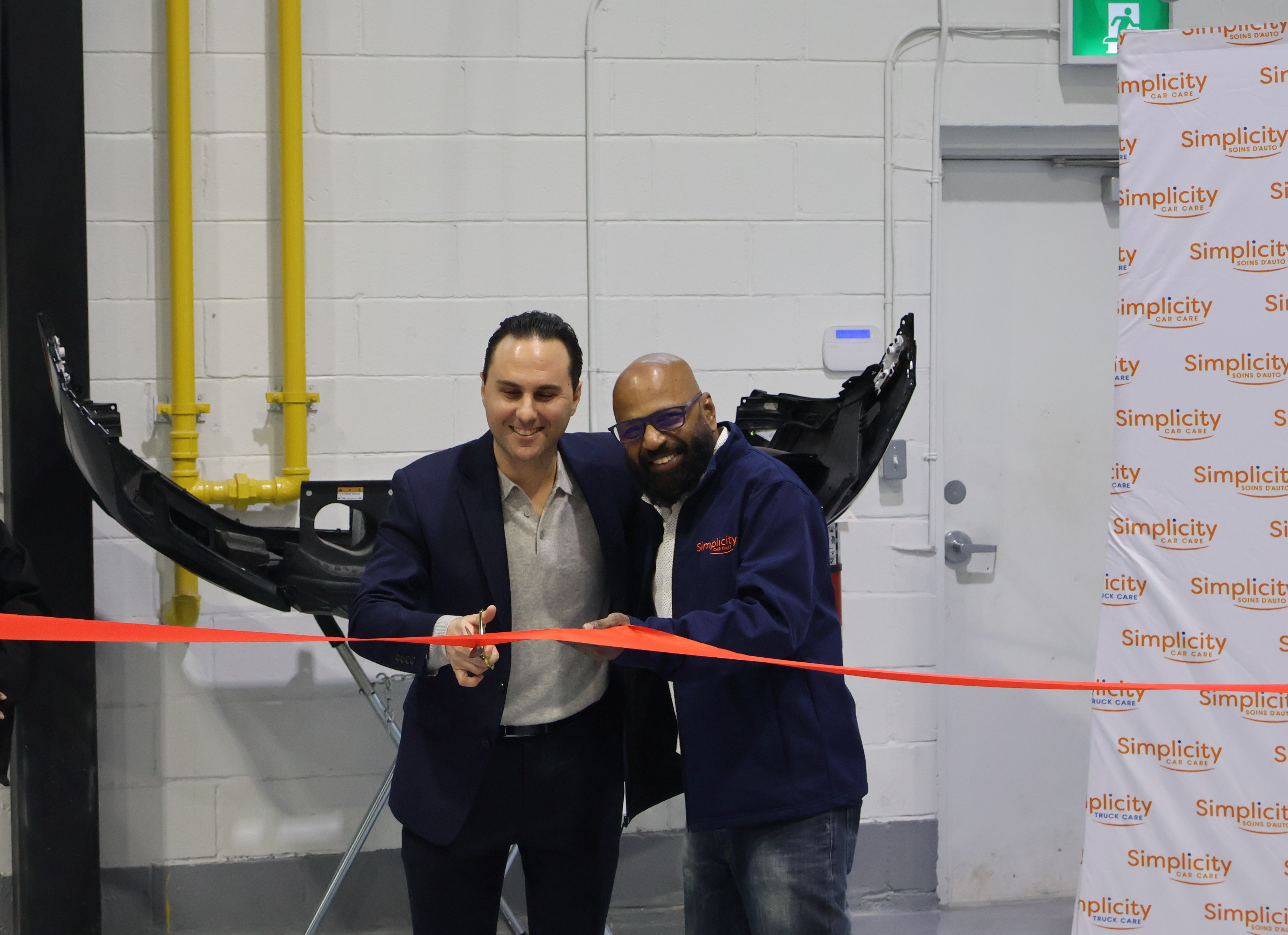 Two professionals cutting a red ribbon at Simplicity corporate event