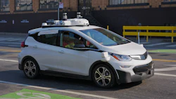 White self-driving Chevrolet Bolt electric vehicle with roof sensors in urban parking lot