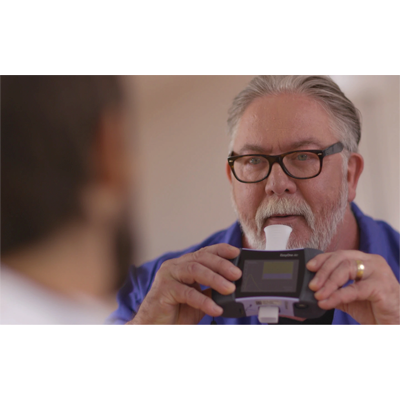Older man with glasses carefully examining a handheld electronic device