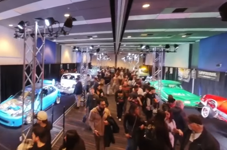 Auto show exhibition with colorful sports cars and crowd of attendees