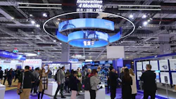 Technology conference with blue circular display and attendees exploring exhibition hall