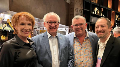 Four professionals smiling together at a business event