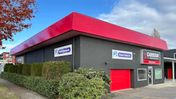 Gray commercial building with red roof, Repair Network and Carstar signs
