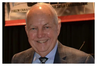 Smiling senior man in brown suit and tie at a conference event