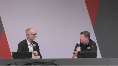 Two professionals discussing on stage with microphones