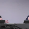 Two professionals in business attire speaking at a conference panel discussion