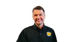 Smiling middle-aged man in black shirt with blue and yellow logo