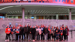 Group of Edmonton Oilers fans posing in arena concourse under 'This is Oil Country' sign