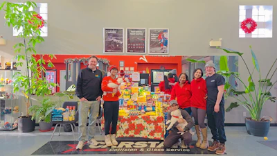 FIRST Collision team poses with holiday food donation display in their service center