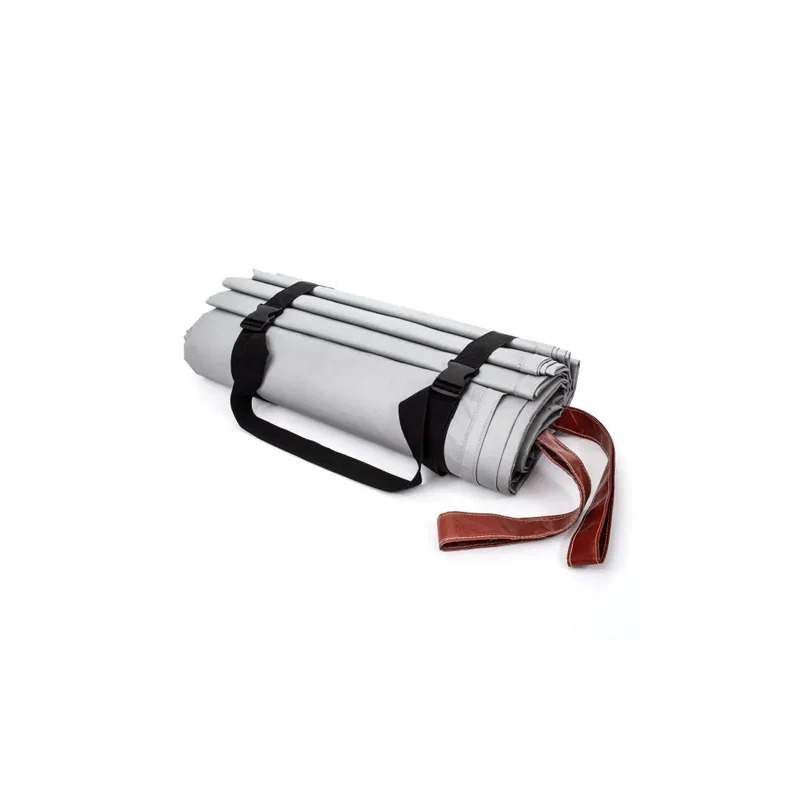 Gray rolled fabric or mat bundled with black straps and red strap