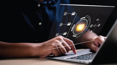 Hands typing on laptop with digital network visualization and glowing tech interface