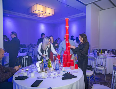 Corporate event with blue lighting, red cup tower, and table setting
