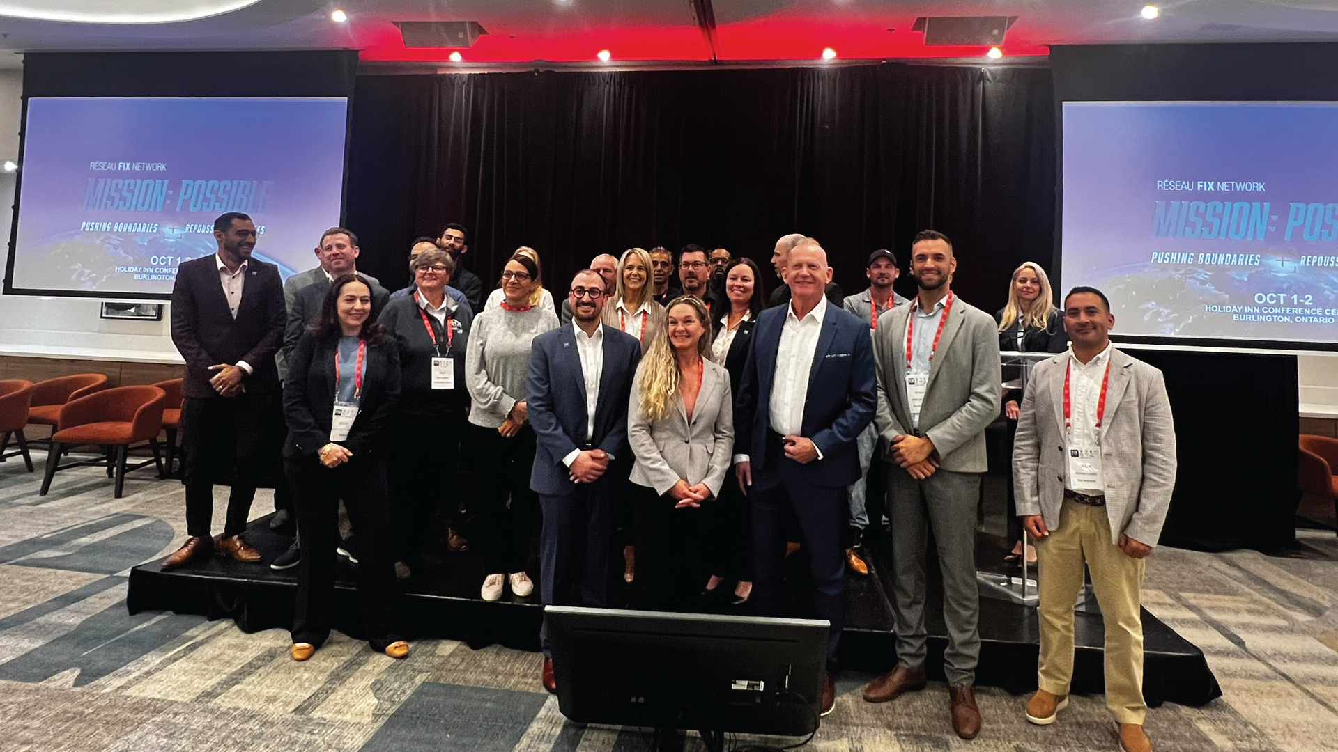 Professional conference group photo with diverse team on stage in business attire