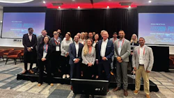 Professional conference group photo with diverse team on stage in business attire