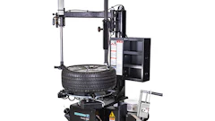 Automotive tire changing machine with black metal frame and mounting equipment