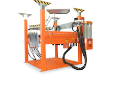 Orange industrial machinery with hydraulic components and safety markings