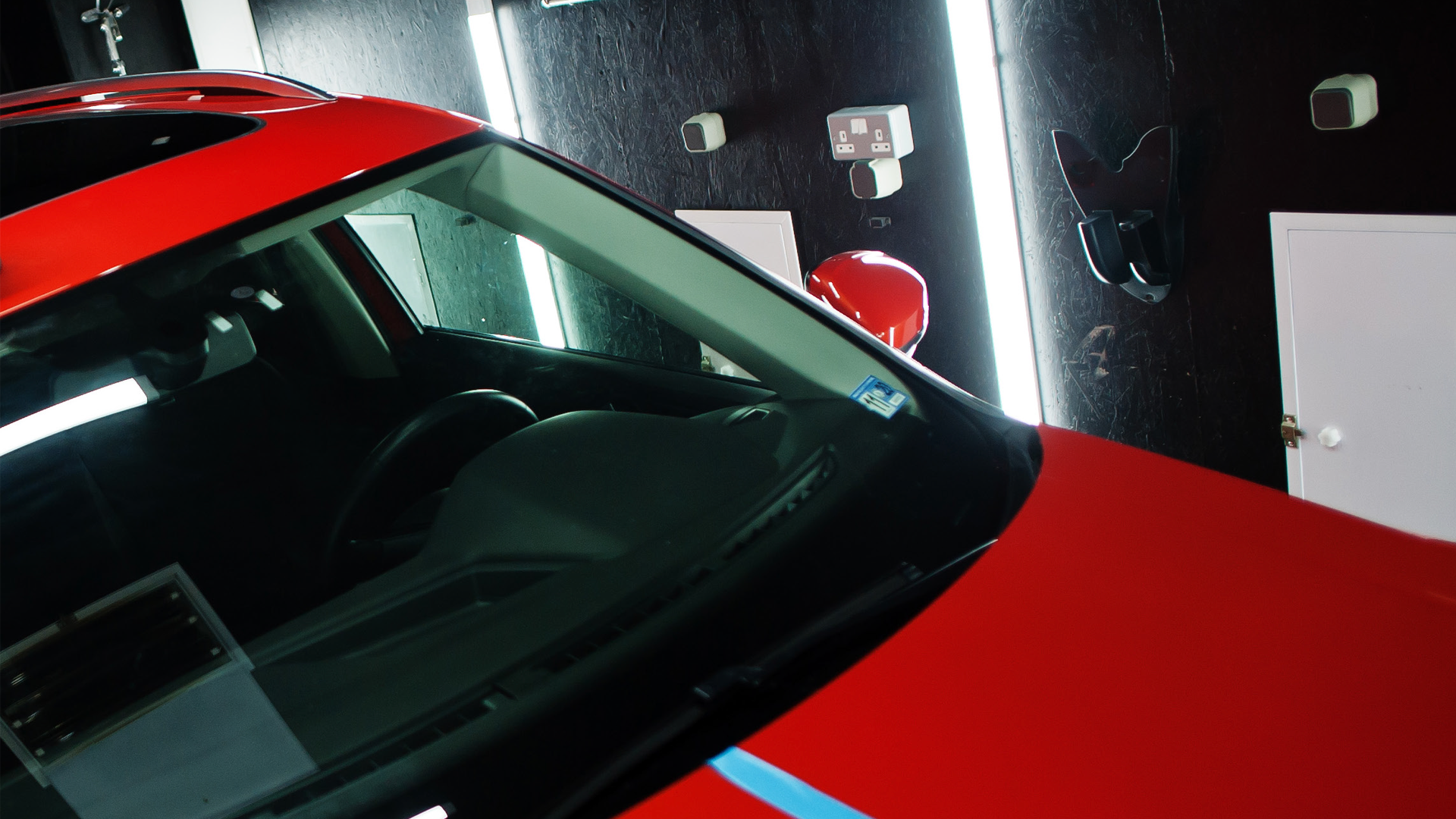 Red sports car windshield and hood in dramatic lighting