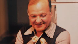 Smiling middle-aged man in striped shirt and dark vest