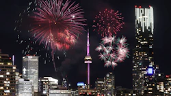 Toronto skyline at night with vibrant red and pink fireworks
