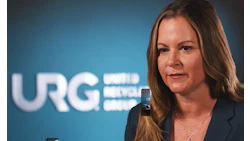 Professional woman speaking in front of URG corporate logo backdrop