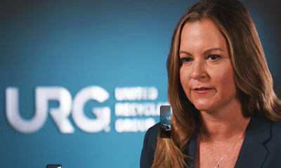 Professional woman speaking in front of URG corporate logo backdrop