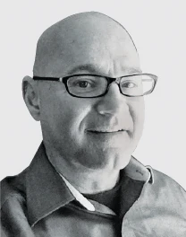 Smiling bald man with glasses in professional headshot