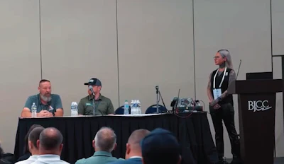 Conference panel discussion with three speakers at BJCC podium