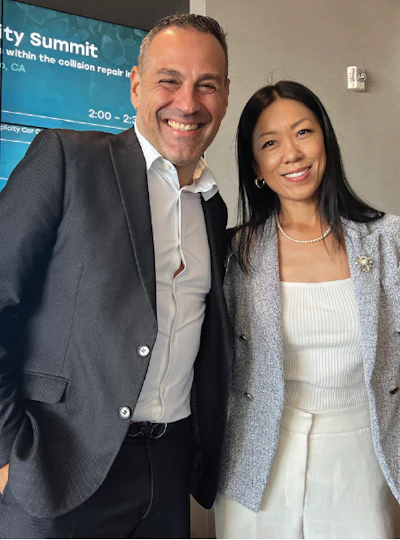 Two professionals smiling together at a business summit event