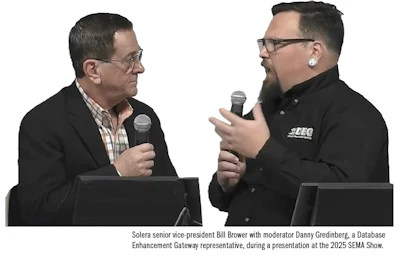 Two men with microphones engaged in discussion at conference podium