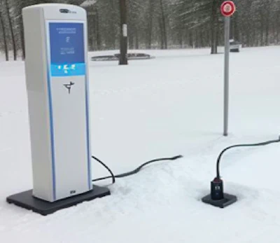 Electric vehicle charging station in snow-covered winter landscape
