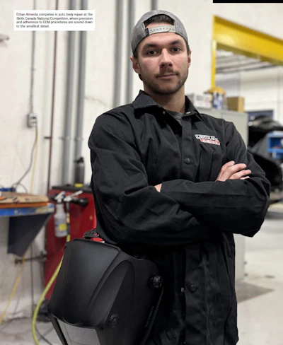 Auto body repair technician in black Lincoln Electric jacket standing in workshop