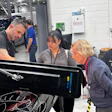 Automotive technicians working together in a high-tech vehicle repair workshop