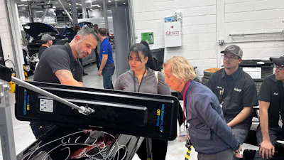 Automotive technicians working together in a high-tech vehicle repair workshop