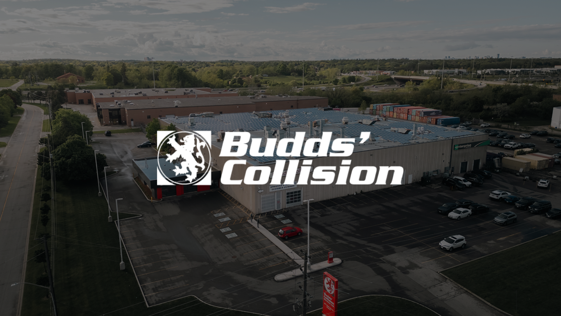 Aerial view of Budds' Collision auto repair shop with logo and parking lot