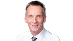 Smiling professional in white shirt and gray tie against white background