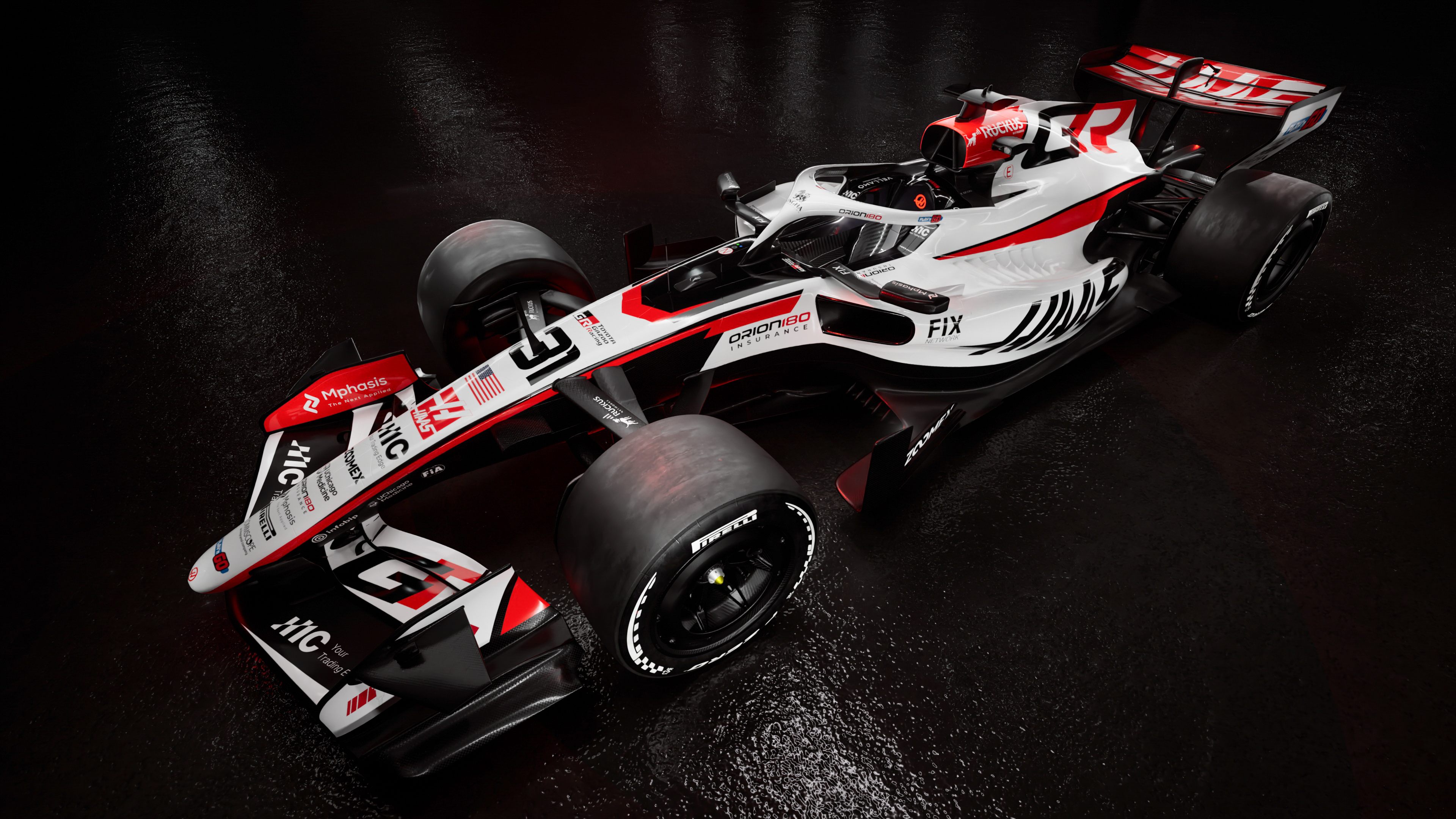 Haas Formula 1 racing car with white, red, and black livery on wet surface