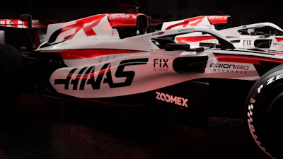 Haas Formula 1 racing car with red and white livery in dark setting