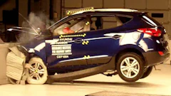 Blue Hyundai SUV undergoing crash test with visible impact and safety testing equipment