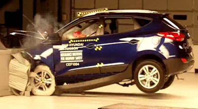 Blue Hyundai SUV undergoing crash test with visible impact and safety testing equipment