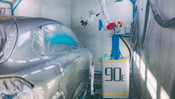 Auto body repair station with silver car in paint booth, equipment with '90e' label