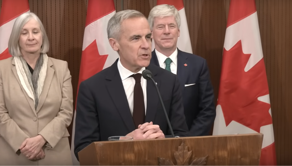 Canadian government press conference with three officials at podium with national flags