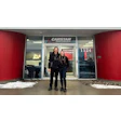 CARSTAR auto collision repair shop entrance with two people standing outside