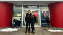 CARSTAR auto collision repair shop entrance with two people standing outside