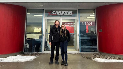 CARSTAR auto collision repair shop entrance with two people standing outside