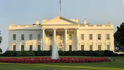 White House with red flower garden and fountain on sunny day