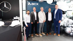 Five businessmen posing at Mercedes-Benz dealership with ACX event backdrop